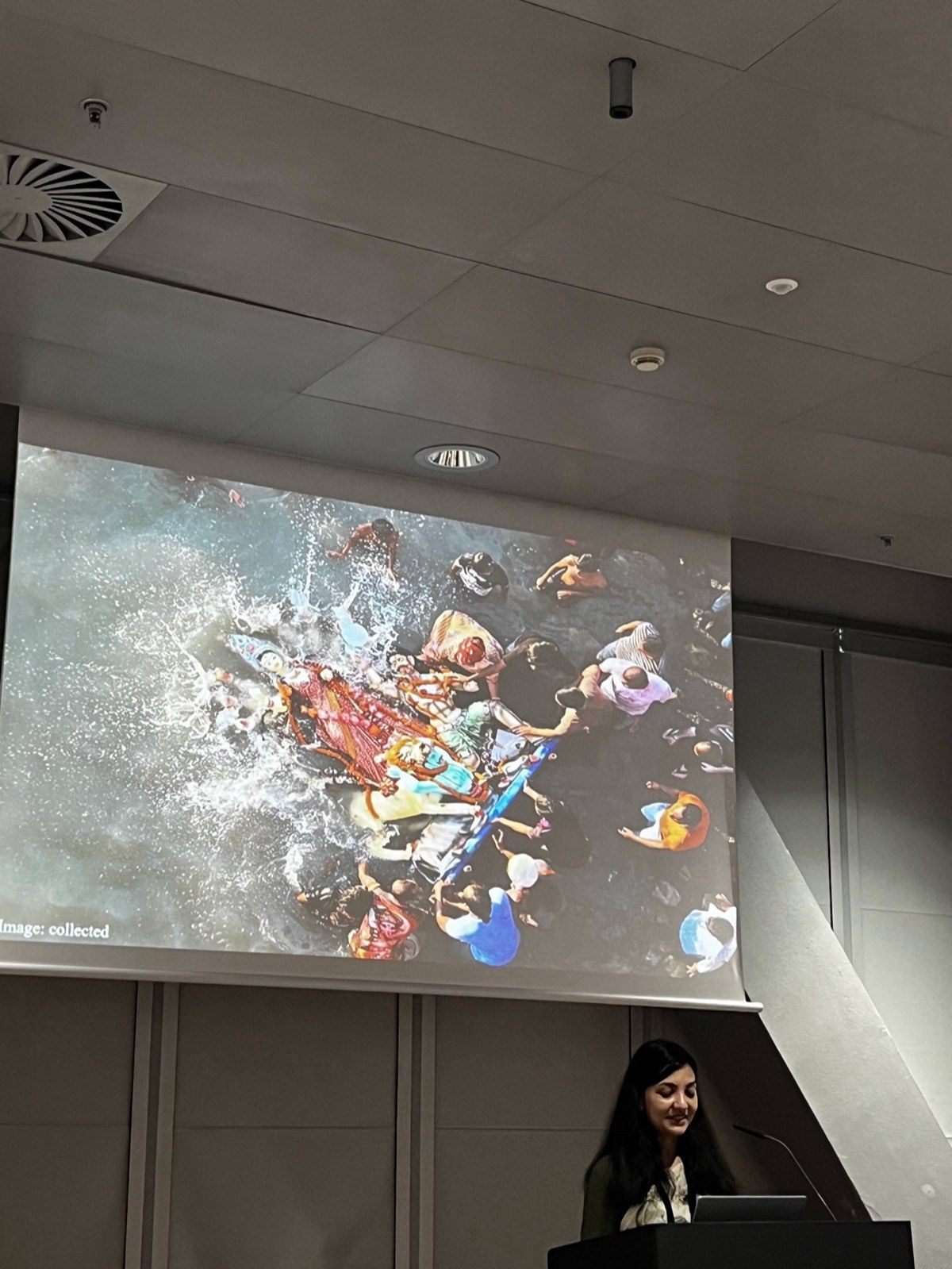 A CHI talk slide showing the immersion of a Durga idol, people in the water around it